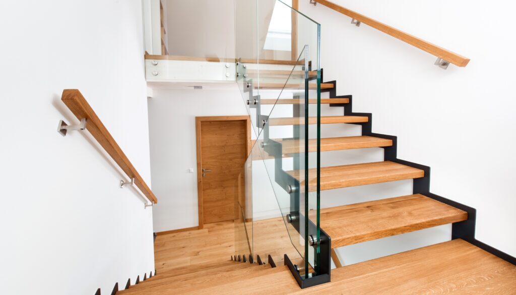 Freitragende Vollholz-Treppe aus massivem Eichenholz mit Glasgeländer in einem hellen Wohnhaus