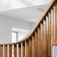 Treppengeländer aus senkrechten Holz-Lamellen in hellem Interieur – Lamellengeländer