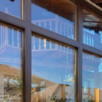 Sanierte, anthrazit verkleidete Fenster- und Wintergarten-Front eines Hauses – KANOVA Fenstersanierung von Steinkogler