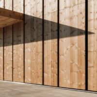 Fassade aus senkrechter Lärchenschalung mit Dachvorsprung, Beispiel für Lärche an der Hausfassade